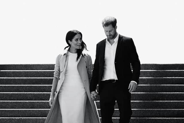 A black and white image of Meghan Markle and Prince Harry walking down a flight of stairs together, hand in hand and smiling (Credit: Netflix)