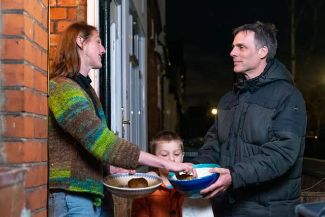 Adam Walters with his son delivering potatoes to one of his neighbours in Lloyds Park, Walthamstow.