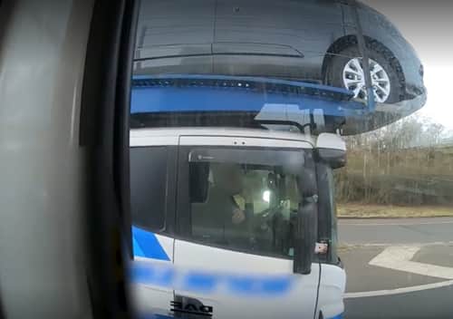 Police officers overtaking a heavily-laden car transporter were shocked to discover the driver was using just one elbow to control the huge vehicle as he travelled along a busy motorway.