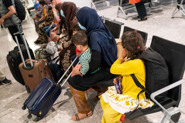 Afghan refugees wait to be processed after arriving on an evacuation flight from Afghanistan, at Heathrow Airport (Photo by DOMINIC LIPINSKI/POOL/AFP via Getty Images)
