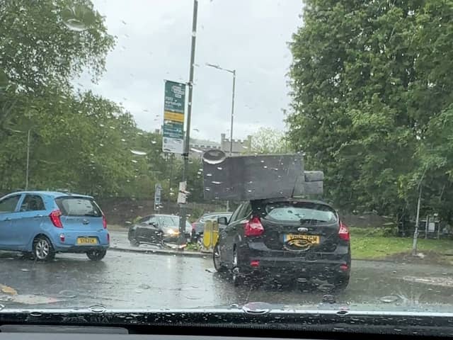 Sofa flies off roof of car and onto busy roundabout.