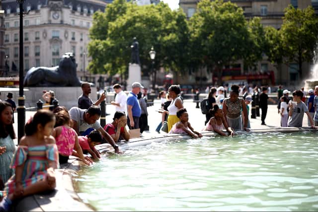 People cool off from the heat at the fountains of Trafalgar square, in central London. (Photo: HENRY NICHOLLS/AFP via Getty Images)