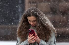 Woman on a smartphone in a snowstorm. Photo: ANATOLII STEPANOV/AFP via Getty Images