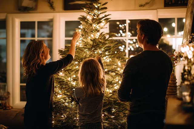 A family gathers to decorate the Christmas tree, a moment that often sparks conversations about traditions, relatives and family history passed down through generations.