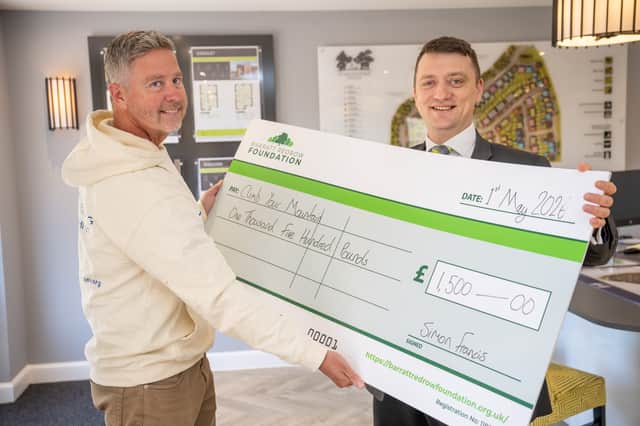 Thomas handing the cheque to Charlie from Climb Your Mountain