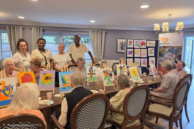 Art Expressions UK CIC team posing with Squires Mews Care home activities coordinators alongside some participants