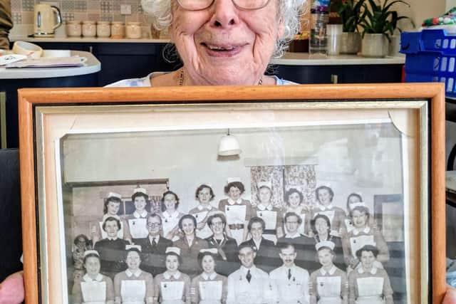Anne proudly holding her class graduation photo.