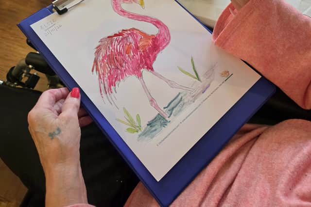 A resident confidently creating artwork during the Wear It Pink: Coffee & Paint event.