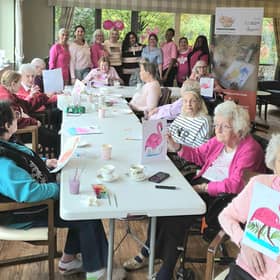 A vibrant moment as Cliftonville Care Home residents and staff pose with their completed artworks from the Wear It Pink: Coffee & Paint art wellbeing session by @ArtExpressionsUKCIC
