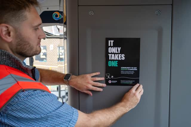 An It Only Takes One women's safety poster being placed on a Stagecoach bus at their Far Cotton depot.