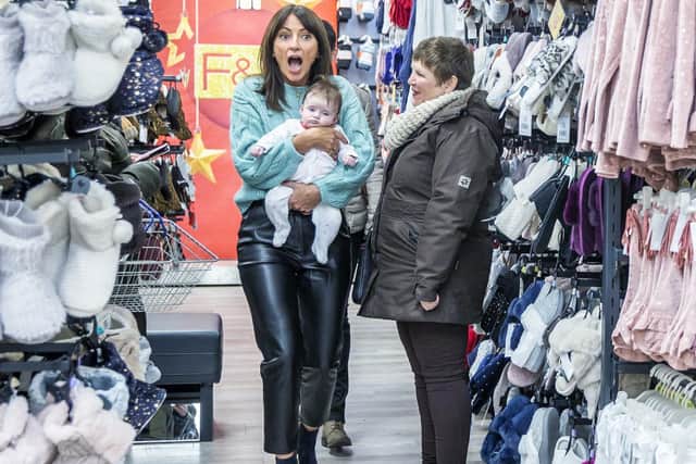 Davina McCall held one of the customers' babies as she went looking for clothes