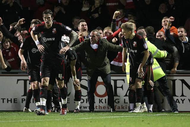Paulo di Canio and the Swindon players celebrate Alan McCormack's dramatic last-gasp winner for the Robins against the Cobblers at Sixfields in 2011
