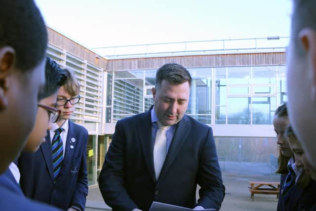 Headteacher Nat Parnell showing the inspection report to his students.
