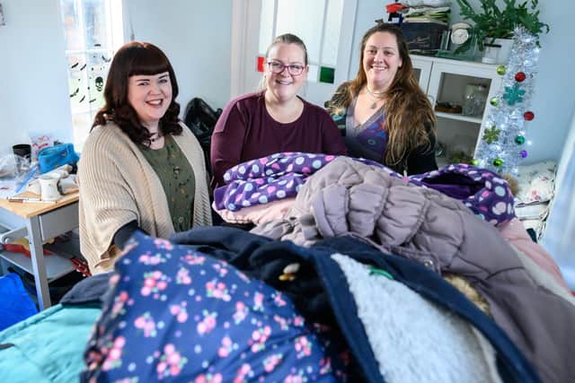Crystal Steel, Katy Smith and Coats for Kids co-founder Rachel Morgan pictured by Louise Smith in the depths of sorting out a mountain of kind-hearted donations.