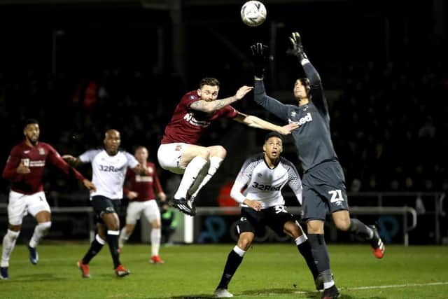 Paul Anderson challenges with Derby goalkeeper Kelle Roos