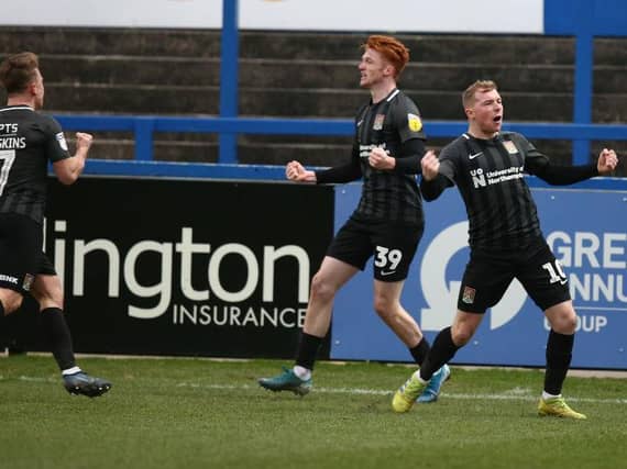 Nicky Adams and Sam Hoskins celebrate with goalscorer Callum Morton. Pictures: Pete Norton