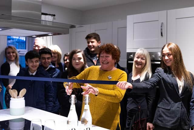 Councillor Judith Shephard cuts the ribbon at the Buckton Fields development launch, along with Bloor Homes staff, customers, and estate agents from Carter Jonas