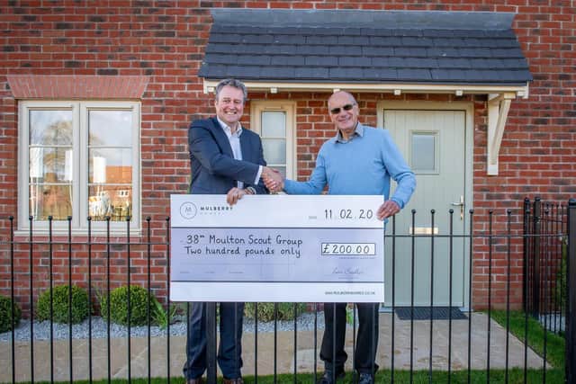 Mulberry Homes managing director Ian Sadler (left) presents Moulton Parish Council chairman David Aarons with a 200 donation for the council's chosen charity, 38th Moulton Scout Group. Photo: Mulberry Homes