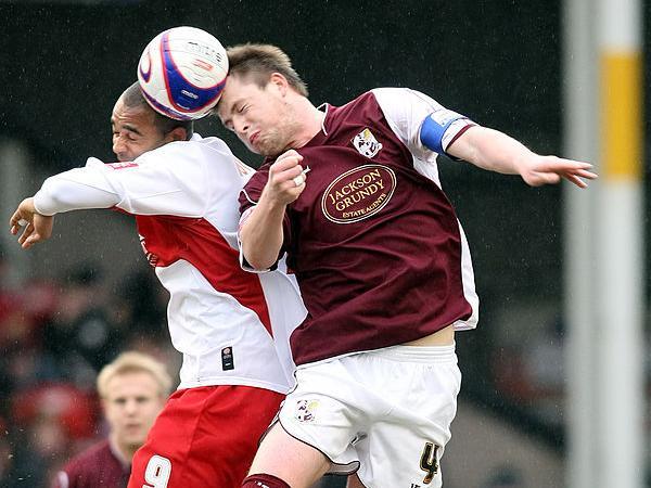 Mark Hughes beats Walsall's Stefan Moore in this aerial battle