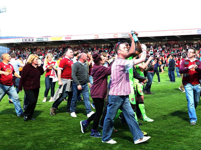Supporters and players mingled on the pitch after the Cobblers' win