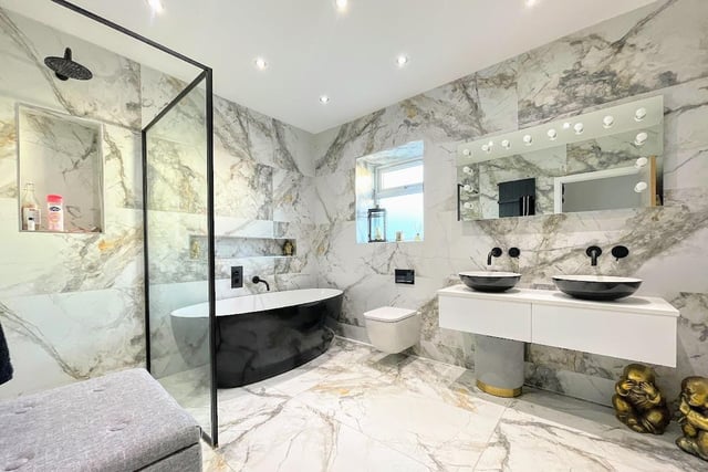 The luxury house bathroom with egg-shaped black bath and separate shower