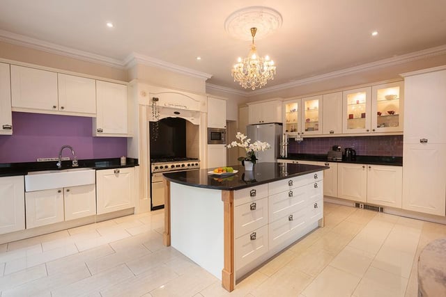 This ,modern fitted kitchen with granite worktops includes a central island with breakfast bar.