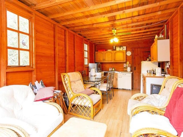 Kitchen space and comfortable seating within this wooden section.