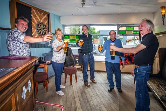 A group of friends pose with their pints in Fiddlers at lunchtime in a section cordoned off for them to just play pinball and darts.