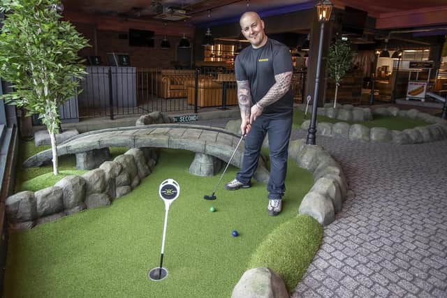 Caddy Shack general manager Peter Petter has a go at the mini-golf course