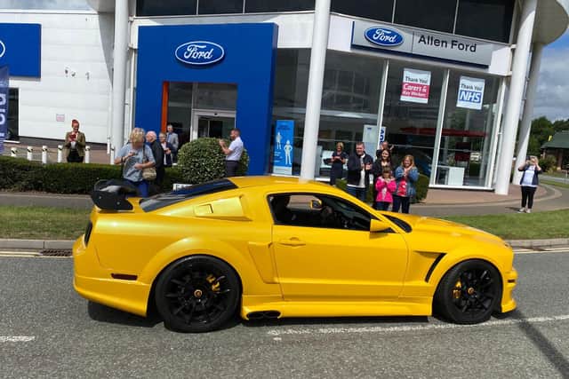 The Scholefields watch the Ford Mustangs pass by outside Allen Ford at Riverside Retail Park. Photo: Simply Mustangs UK