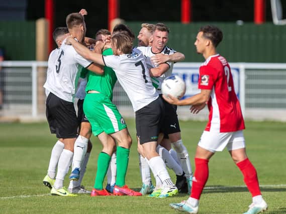 The Gateshead players celebrate while Brackley Town's Ellis Myles looks dejected after his penalty was saved in the decisive moment in the shoot-out. Picture by Kirsty Edmonds