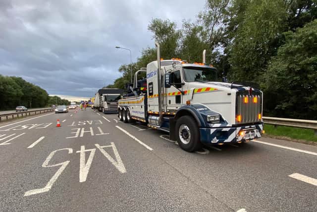 Recovery trucks wait for the all-clear to tow away the stricken HGV