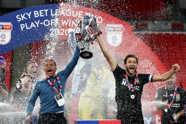 Keith Curle (left) lifts the league two play-off trophy with Charlie Goode