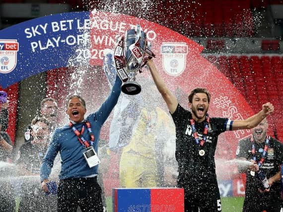 Keith Curle (left) lifts the league two play-off trophy with Charlie Goode
