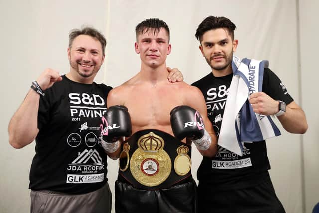 Kieron Conway shows off his title belt, flanked by his dad and trainer James (left) and Alex Le Geuvel