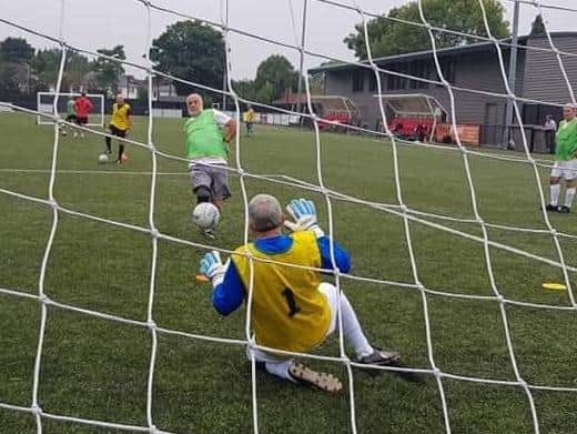 David Poole faces a shot in goal during training with Moulton Masters Walking Football Club