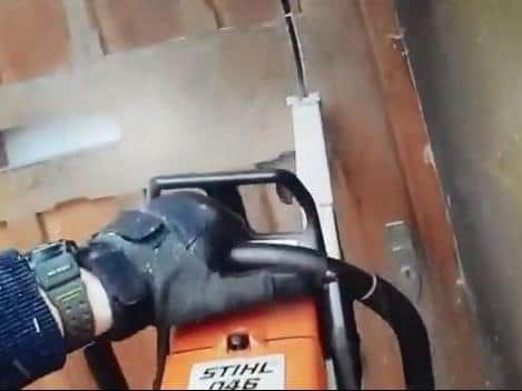 One armed officer chops through the door with a chain saw. Photos: Northamptonshire Police