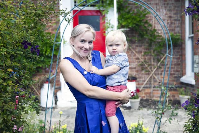 Emily Armstrong pictured holding her son in her tearoom gardens. Pictures by Kirsty Edmonds.