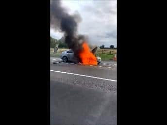 The Vauxhall on fire on the hard shoulder on the M1 near Northampton