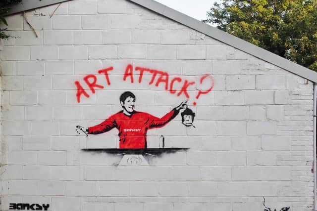 The piece appears to be inspired by an online rumour that Art Attack star Neil Buchanan is the true identity of street artist Banksy.