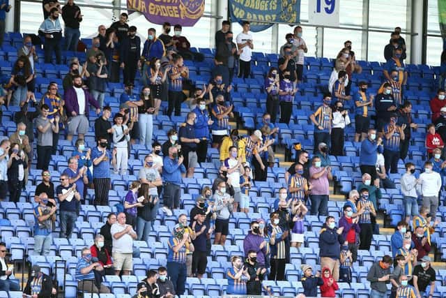 Socially-distanced Shrewsbury fans watch their team in action against the Cobblers.