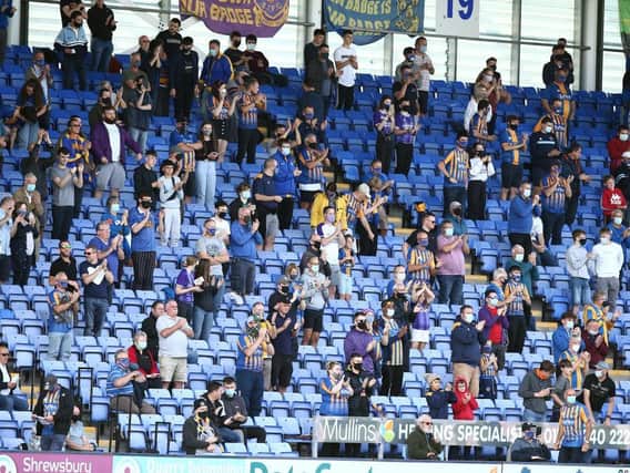 Socially-distanced Shrewsbury fans watch their team in action against the Cobblers.