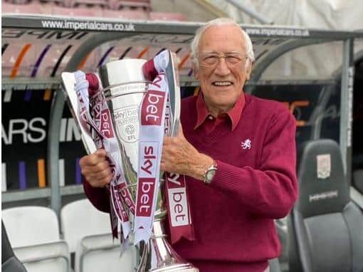 Northampton Town FC fan Michael with the Sky Bet League Two play-offs trophy at the PTS Academy Stadium