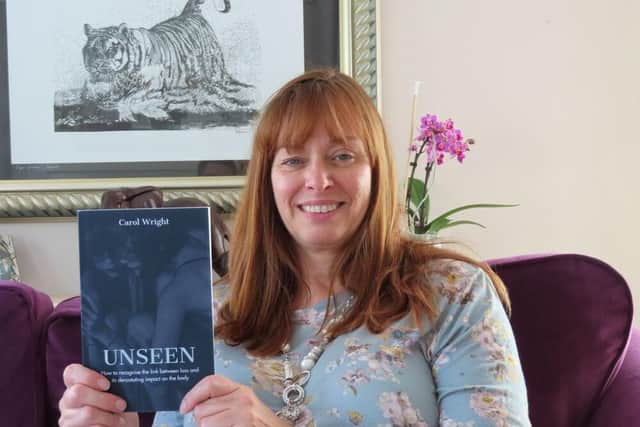 Carol Wright with her grief and loss advice book.