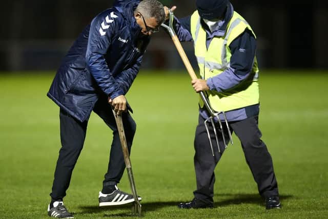 Keith Curle helped get the pitch in a fit state following torrential rain before Tuesday's game.