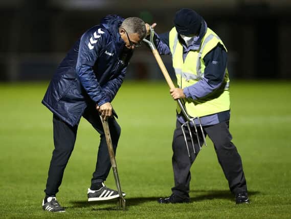 Keith Curle helped get the pitch in a fit state following torrential rain before Tuesday's game.