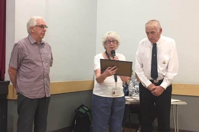 Enid Freeman presents Alan Kingston, from 11th Northampton Boys’ Brigade, with a certificate for 50 years of fundraising for DOPWA, alongside treasurer David Winter