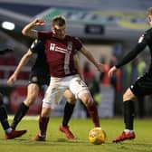 Chris Long fights for possession when Cobblers last played Wigan in January 2018.