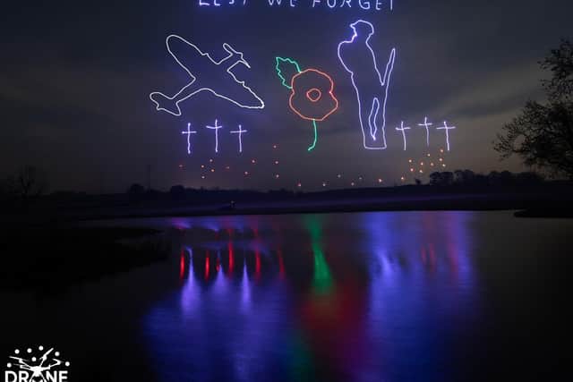 The poignant display pictured reflecting off the water at Winwick Hall on Sunday night. Copyright: Drone Swarm