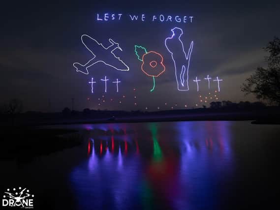 The poignant display pictured reflecting off the water at Winwick Hall on Sunday night. Copyright: Drone Swarm